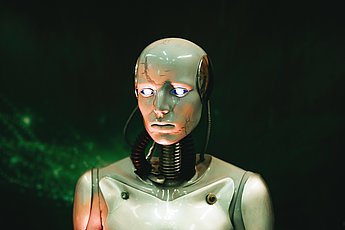 Grafik: Menschenähnlicher Roboter, der mit leuchtenden Augen Richtung Kamera blickt